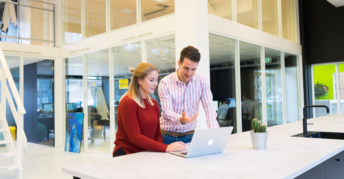 Photo of a Man and Woman Using a Laptop Computer